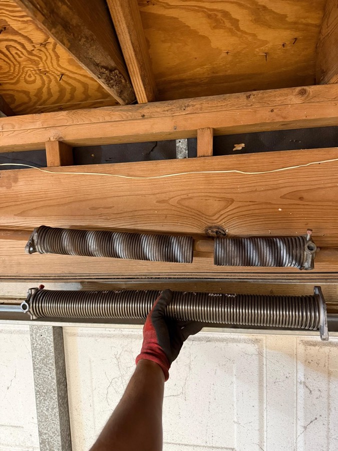 Snapped garage door torsion spring above a door